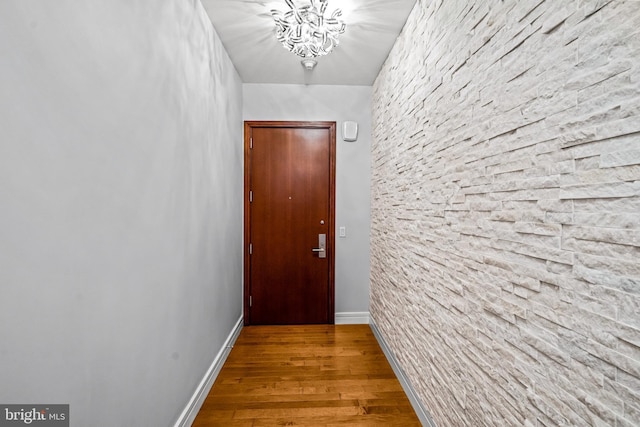 doorway to outside featuring a chandelier and wood-type flooring