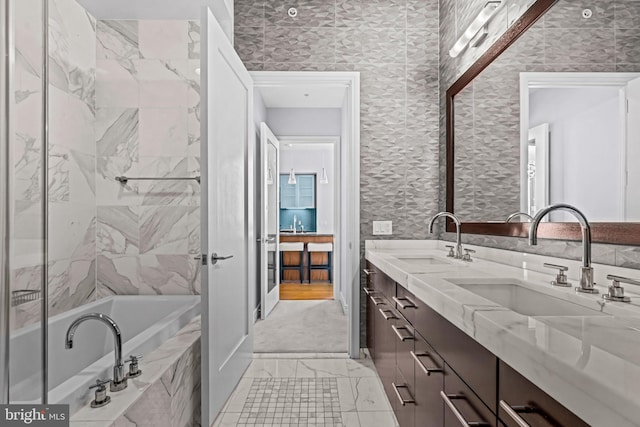 bathroom with vanity and a relaxing tiled tub