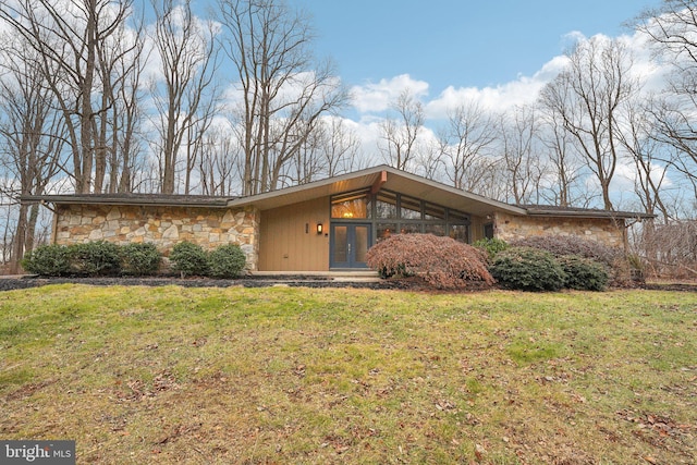 single story home with french doors and a front lawn