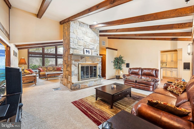 carpeted living room with vaulted ceiling with beams and a stone fireplace