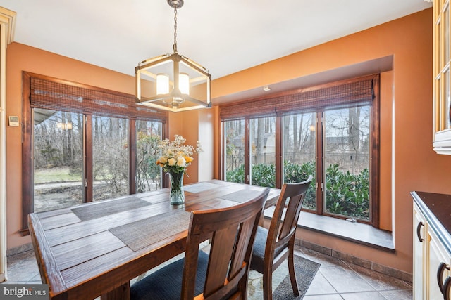 dining area with light tile patterned floors and an inviting chandelier