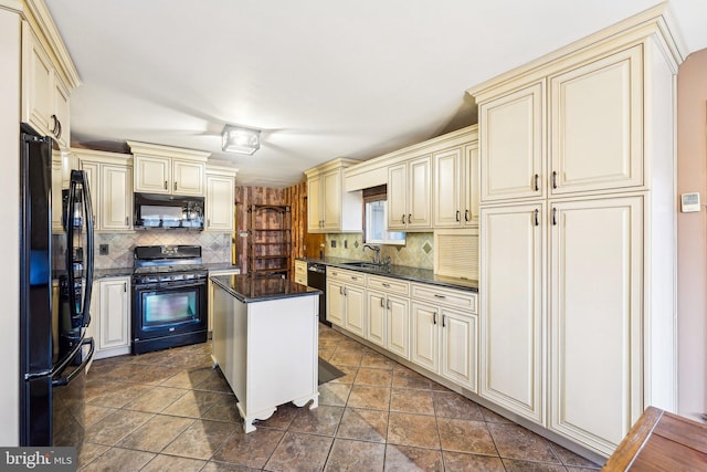 kitchen with sink, a center island, cream cabinetry, decorative backsplash, and black appliances