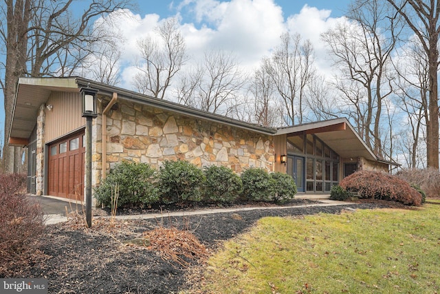 view of side of property with a lawn and a garage