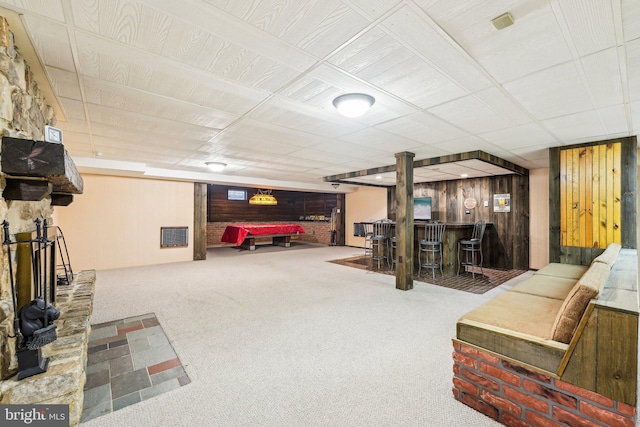 interior space featuring carpet, indoor bar, and wood walls