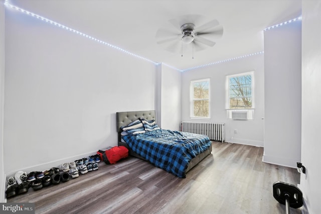 bedroom with wood-type flooring, radiator, and ceiling fan