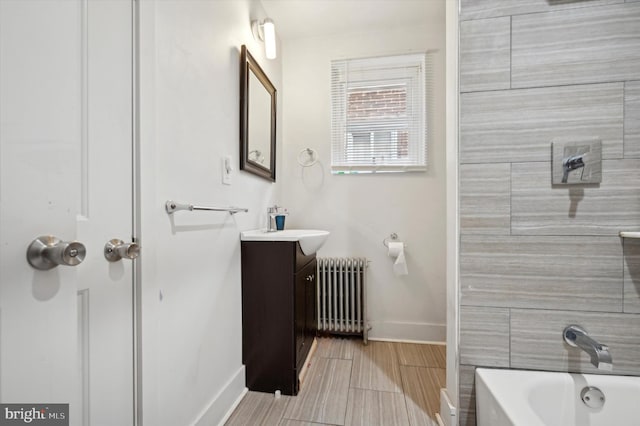 bathroom featuring vanity, radiator heating unit, and washtub / shower combination