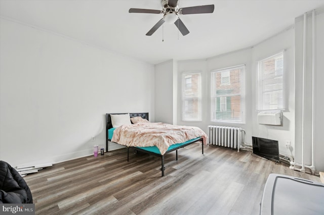 bedroom featuring hardwood / wood-style floors, radiator, and ceiling fan