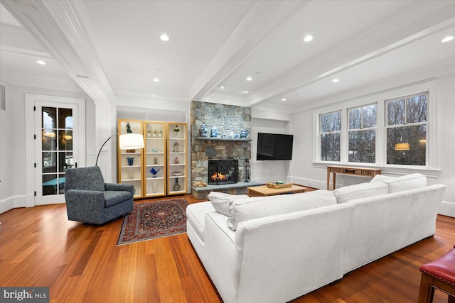 living room featuring a wealth of natural light, crown molding, hardwood / wood-style floors, and a fireplace