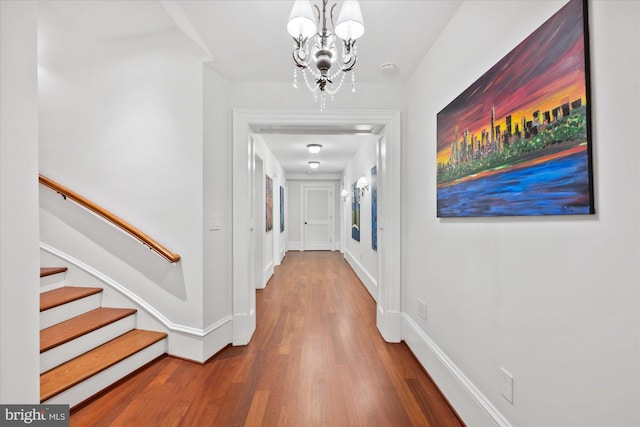 hall featuring hardwood / wood-style floors and a notable chandelier