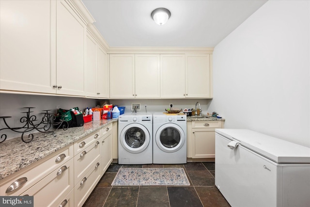 laundry area featuring cabinets, washing machine and dryer, and sink