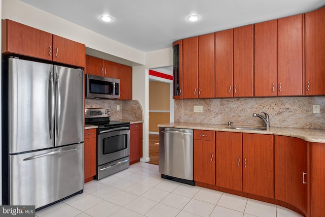 kitchen with sink, light tile patterned floors, stainless steel appliances, and tasteful backsplash