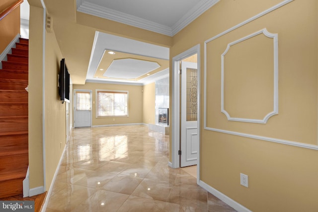 hallway featuring ornamental molding and a tray ceiling