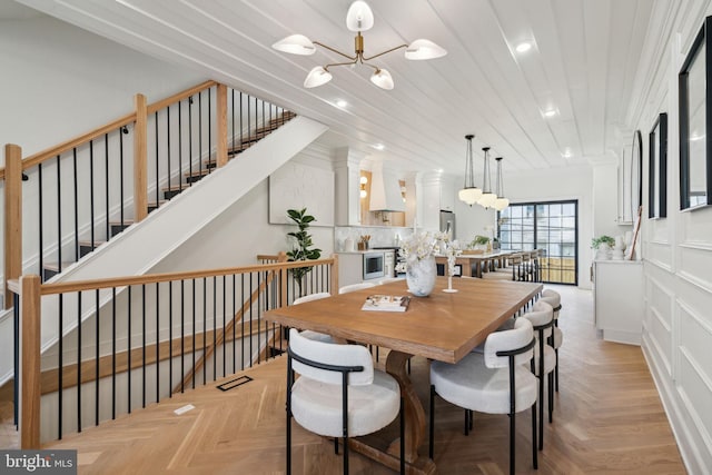 dining room featuring light parquet flooring and a notable chandelier