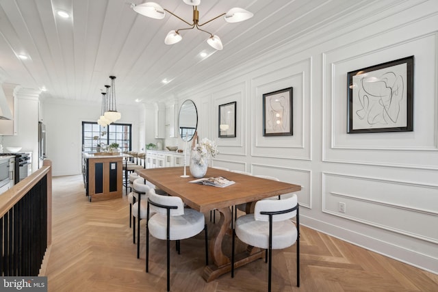 dining area featuring light parquet floors and an inviting chandelier