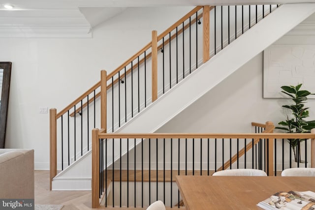 stairs featuring parquet flooring and crown molding