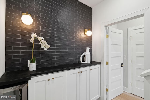 interior space featuring white cabinets, light hardwood / wood-style floors, and backsplash