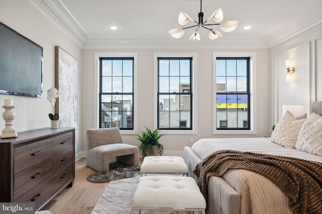 bedroom with light hardwood / wood-style floors, ornamental molding, and a notable chandelier