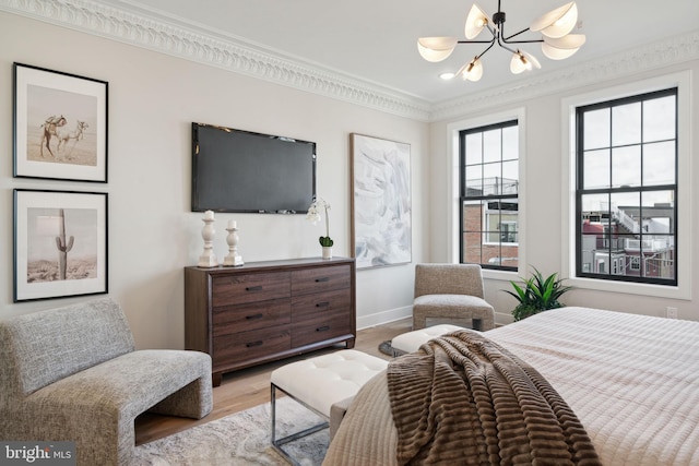 bedroom with a chandelier, light wood-type flooring, and crown molding