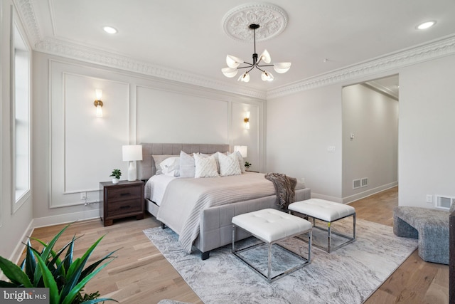 bedroom with a chandelier, light hardwood / wood-style floors, and ornamental molding