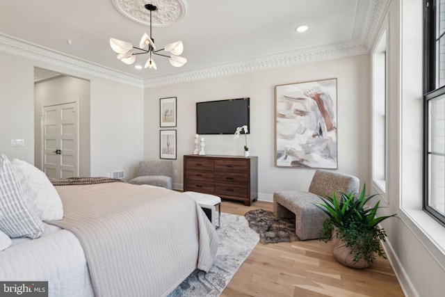 bedroom featuring light hardwood / wood-style floors, a notable chandelier, and ornamental molding