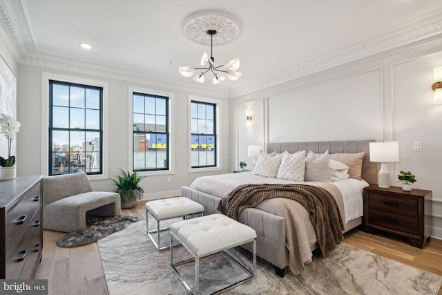 bedroom featuring crown molding, light hardwood / wood-style floors, and a notable chandelier