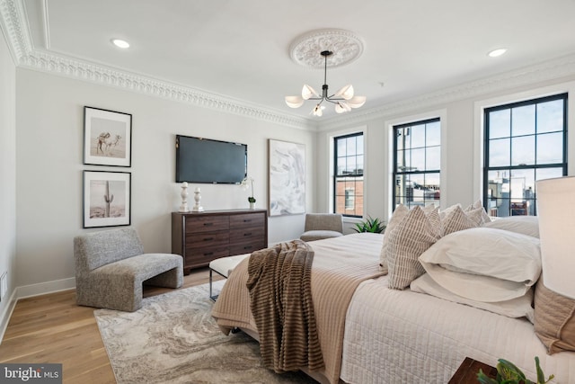 bedroom featuring crown molding, a chandelier, and light wood-type flooring