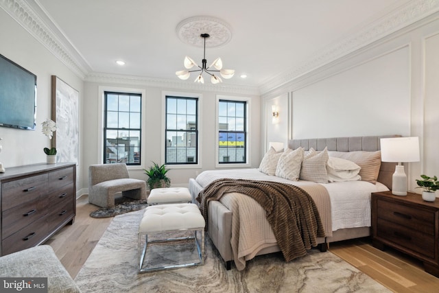 bedroom with a chandelier, light hardwood / wood-style floors, crown molding, and multiple windows