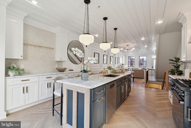 kitchen featuring white cabinetry, a center island, ceiling fan, and stainless steel appliances