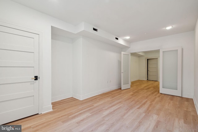 empty room with french doors and light hardwood / wood-style flooring