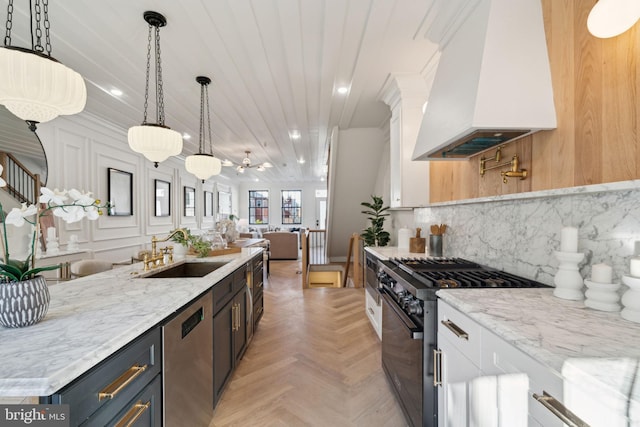 kitchen featuring custom exhaust hood, stainless steel appliances, ceiling fan, decorative light fixtures, and white cabinets