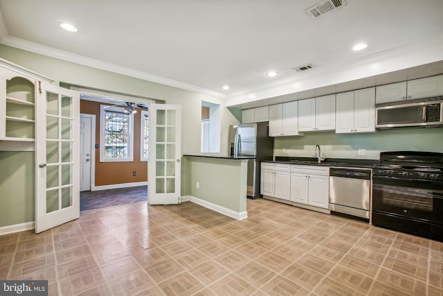 kitchen with appliances with stainless steel finishes, white cabinetry, french doors, and crown molding