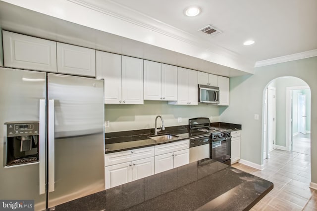 kitchen with white cabinets, stainless steel appliances, ornamental molding, and sink