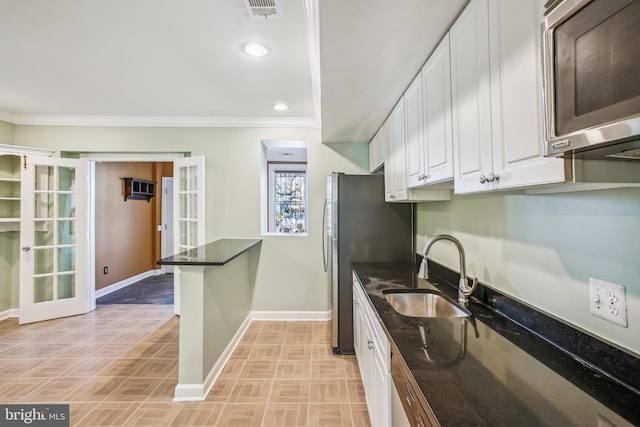 kitchen with sink, white cabinets, french doors, and appliances with stainless steel finishes