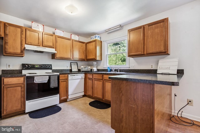 kitchen with kitchen peninsula, sink, and white appliances