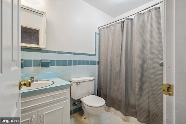 bathroom featuring a shower with curtain, vanity, tile walls, tile patterned flooring, and toilet