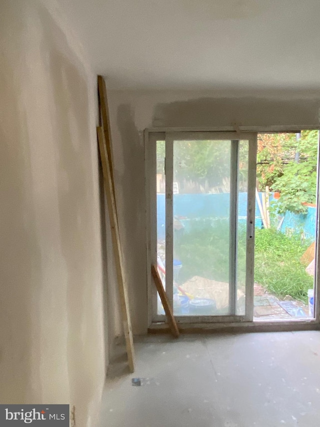 doorway to outside featuring a water view and concrete flooring