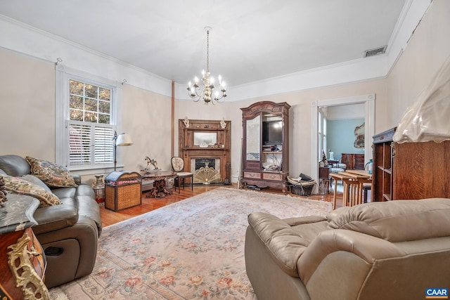 living room with light hardwood / wood-style flooring, ornamental molding, and a notable chandelier