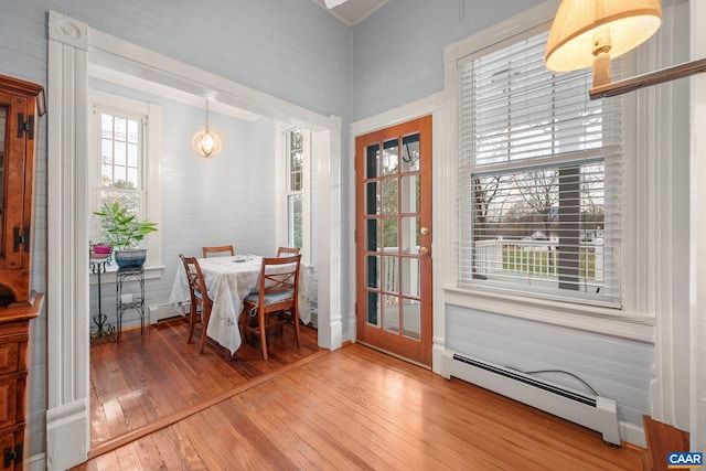 dining space with hardwood / wood-style floors and a baseboard radiator