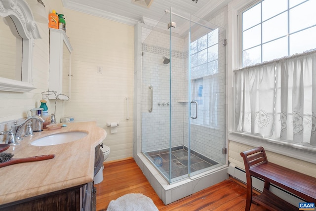 bathroom with toilet, wood-type flooring, and ornamental molding