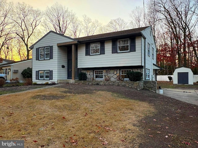 split foyer home featuring a yard and a storage shed