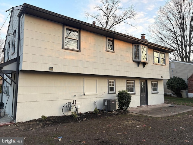 view of front facade with central AC and a patio area