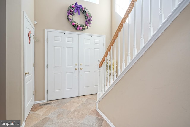 foyer entrance featuring a towering ceiling