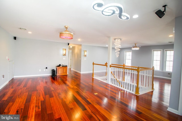 unfurnished room featuring dark hardwood / wood-style floors and an inviting chandelier