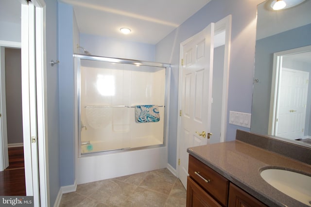 bathroom featuring vanity, tile patterned floors, and enclosed tub / shower combo