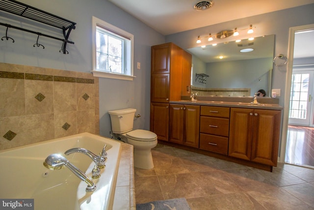 bathroom featuring tile patterned flooring, a tub to relax in, toilet, and a healthy amount of sunlight