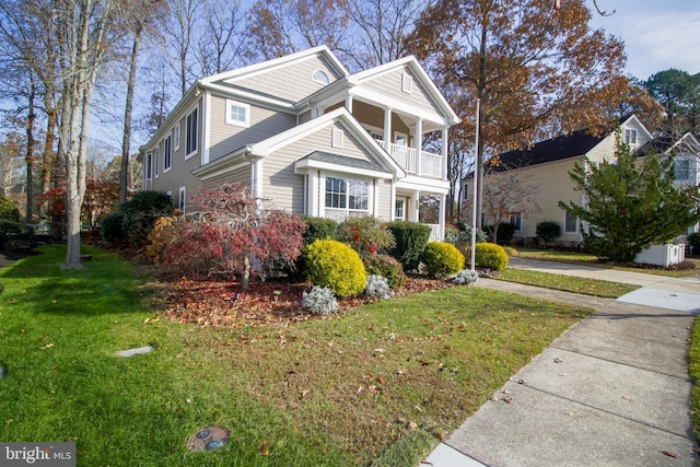 view of front of property featuring a balcony and a front lawn