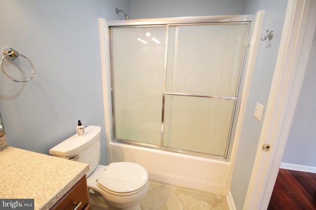 full bathroom with combined bath / shower with glass door, hardwood / wood-style floors, vanity, and toilet