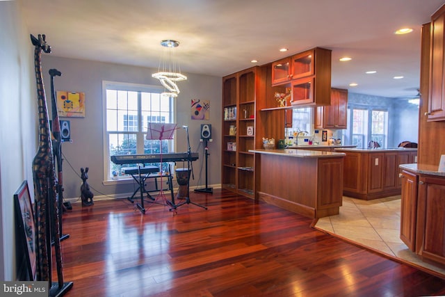 interior space featuring hanging light fixtures, plenty of natural light, wood-type flooring, and an inviting chandelier