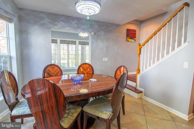 tiled dining area featuring an inviting chandelier