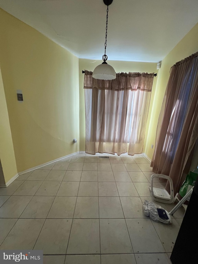 unfurnished dining area featuring tile patterned flooring